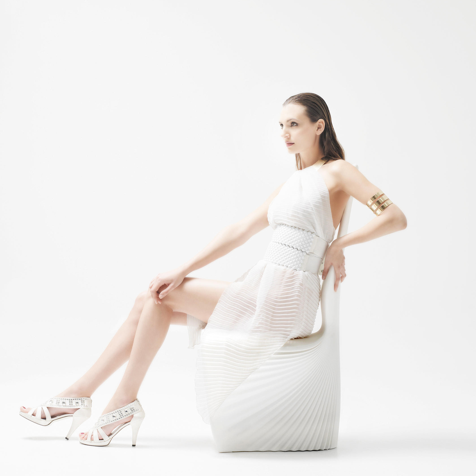 A woman posing on a white biophilia dining chair by Vondom.