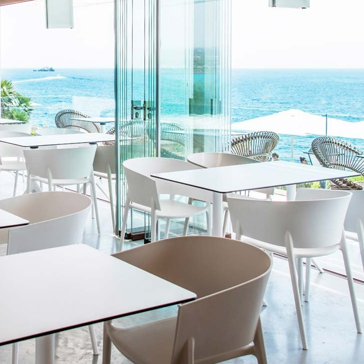 White and pistachio coloured Africa armchairs by Vondom in seaside restaurant.